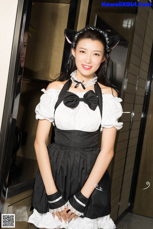 A woman dressed as a maid posing for a picture.