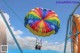 A couple of people that are parasailing in the sky.