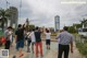 A group of people taking pictures of a water tower.