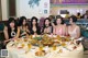 A group of women sitting around a table eating food.