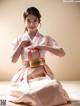 A woman in a pink hanbok is posing for a picture.