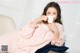 A woman sitting on a couch holding a cup of coffee.