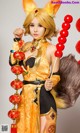 A woman dressed in a fox costume holding a red lantern.