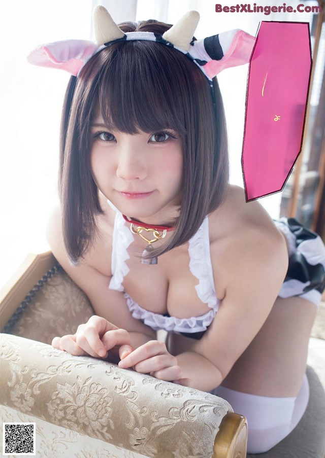 A woman in a cow costume sitting on a couch.