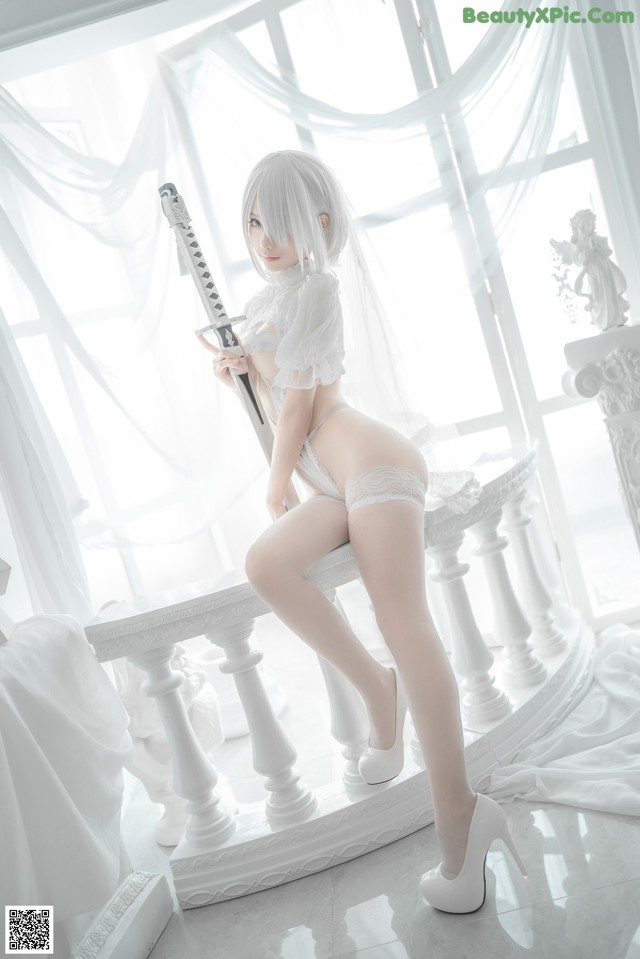 A woman in a white lingerie holding a sword.