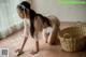 A woman in a white lingerie cleaning the floor with a cloth.