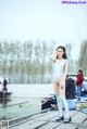 A woman standing on a dock next to a body of water.