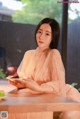 A woman sitting at a table with a plate of food.