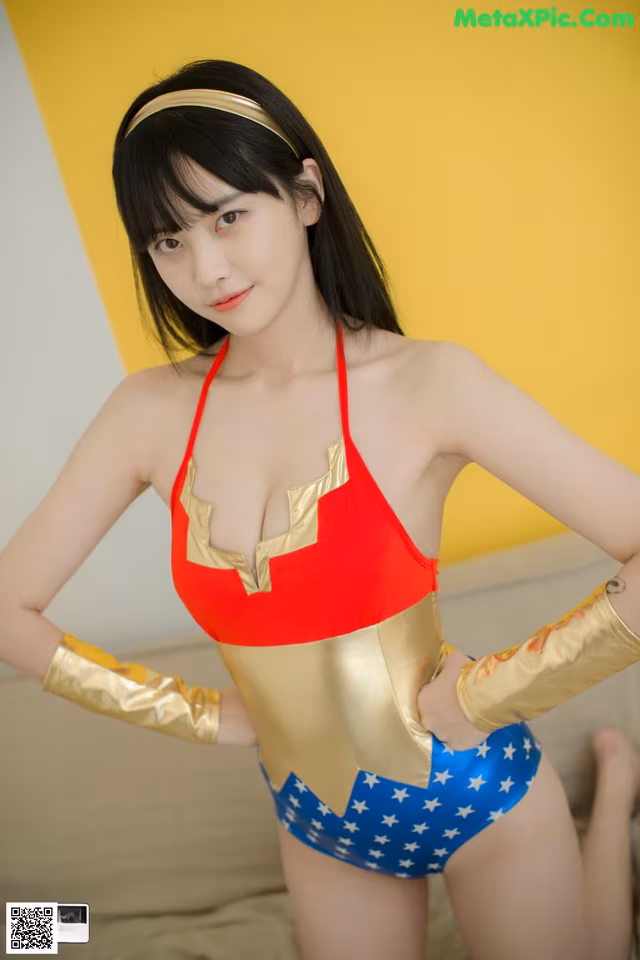 A woman in a red and gold bathing suit posing for a picture.