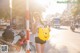 A woman holding a Winnie the Pooh balloon on a city street.